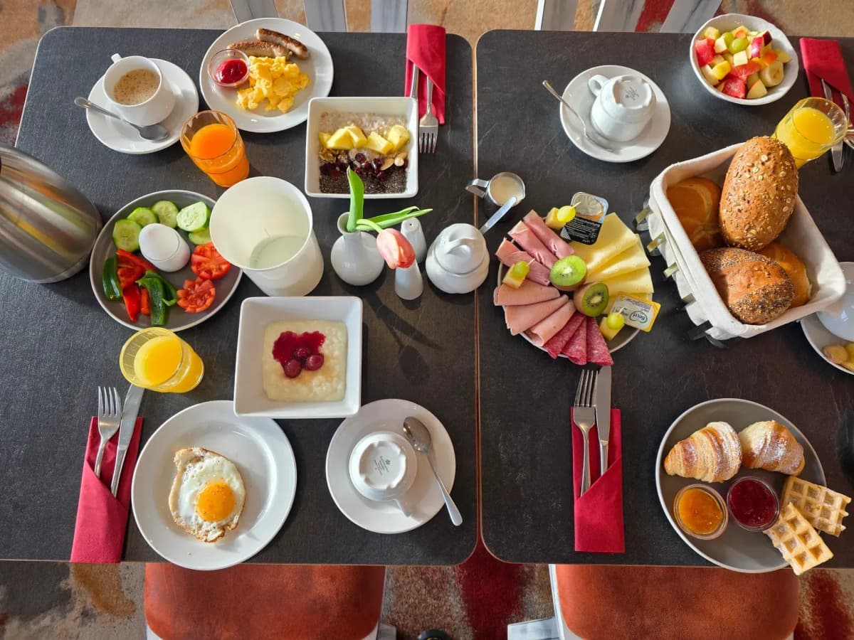 Gedeckter Frühstückstisch mit Sonnenlicht und frischen Blumen